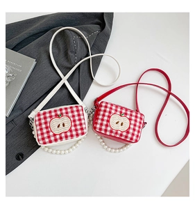 Detail of plaid makeup bags with apple embroidery and elegant pearl chain handles