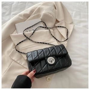 Close-up of black quilted small square bag with silver turn-lock and chain strap detail