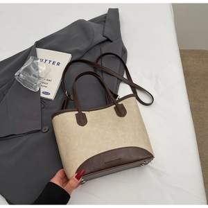 Close-up of contrast stitching tote bag with metal base studs and premium faux leather detail