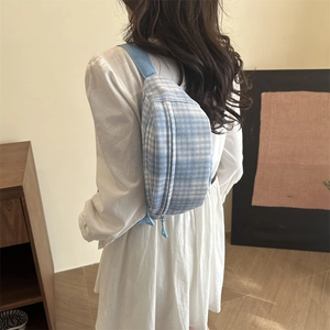 Cute light blue plaid chest bag with adjustable strap shown on model for back carrying
