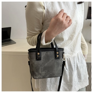 Sac seau gris bicolore porté en bandoulière avec une tenue de bureau chic