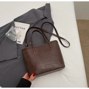 Detailed shot of dark brown vintage faux leather tote bag with metal bottom studs