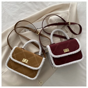 Detail of quilted suede crossbody bags with white shearling trim and metal locks