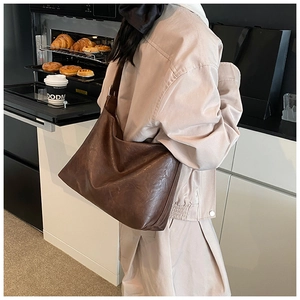 Detail view of large dark brown leather tote bag with soft texture in casual style