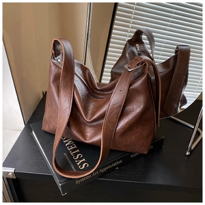 Detail view of vintage dark brown faux leather shoulder bag with zipper and metal buckle