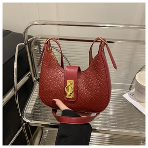 Close-up of deep red woven texture and golden metal lock on hobo crescent bag