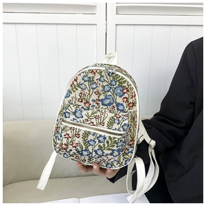 Detailed close-up of floral jacquard texture and white PU leather on the mini backpack