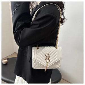 Détail du sac bandoulière blanc matelassé avec logo SS doré et pompon métallique élégant