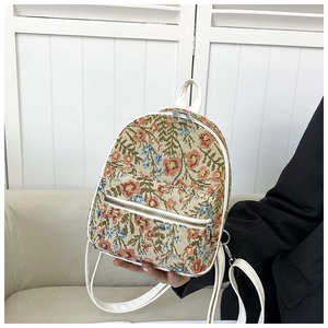 Detail of mini floral tapestry backpack with white leather trim and silver zipper