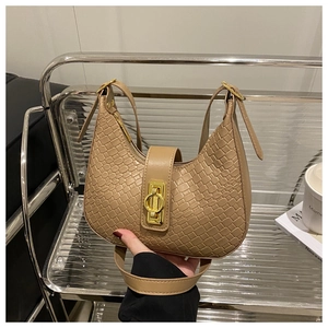 Close-up of khaki woven texture hobo bag with a gold metal clasp and adjustable strap