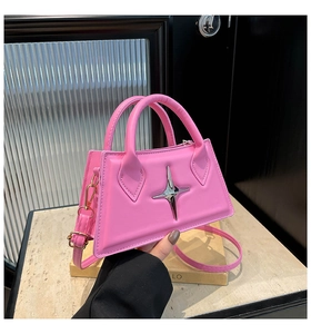 Detail of pink trapezoid handbag with silver star ornament and dual tubular handles