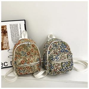 Close-up of vintage floral tapestry mini backpacks with white faux leather straps