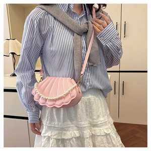 Pink shell-shaped crossbody bag with decorative pearl chain and embossed texture detail