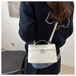 Back view of model wearing off-white leather crossbody square bag in minimalist interior