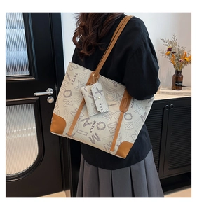 Détail du sac cabas en toile avec anses en cuir marron et petite pochette amovible