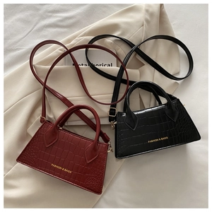 Close-up of crocodile texture on vintage red and black stylish mini square handbags