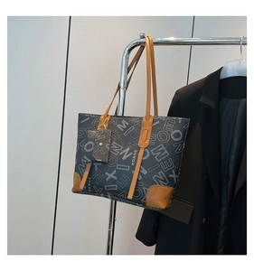 Détail du sac cabas gris avec motifs de lettres rétro et petite pochette assortie