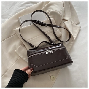 Detailed view of dark brown box bag with silver zippers and adjustable shoulder strap