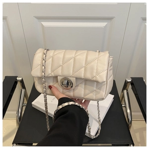 Détail du sac à bandoulière matelassé beige avec chaîne en argent et fermoir tournant