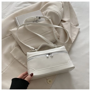 Detail of white square PU leather handbag with zipper closure and adjustable shoulder strap