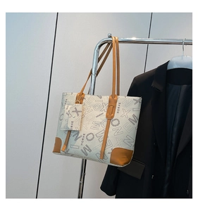 Détail macro du grand sac cabas avec lanières marron et motifs de lettres imprimés