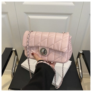Détail du sac à bandoulière matelassé rose avec fermoir rotatif argenté et chaîne