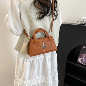 Sac bandoulière en similicuir marron avec étoile argentée porté par un mannequin