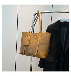 Gros plan sur un sac cabas aux tons terre avec monogramme vintage et coins renforcés