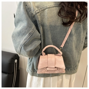 Close-up of pink mini hourglass handbag with marble leather texture on female model