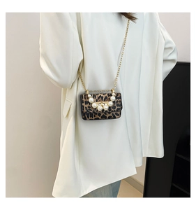 Detailed view of mini leopard print crossbody bag with large pearl handle and gold chain