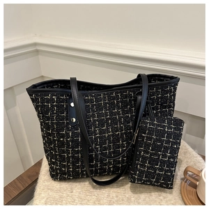 Dettaglio della borsa tote in tweed con trama intrecciata nero oro e mini pochette