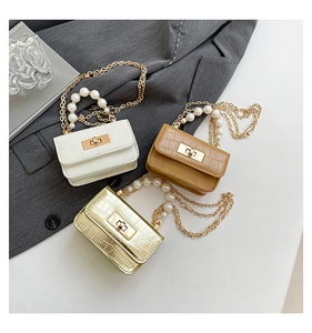 Detail of crocodile pattern mini bags with pearl handles and metallic lock closure