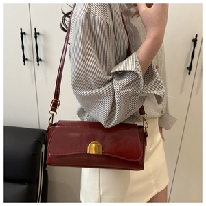 Détail du sac baguette en cuir ciré bordeaux avec boucle en métal doré vintage