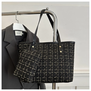 Dettaglio della borsa tote in tweed nero con borchie dorate e pochette coordinata