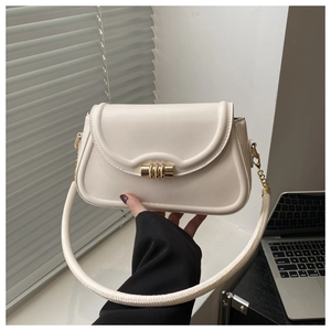 Detail of cream white leather handbag with golden ring buckle and tubular handle