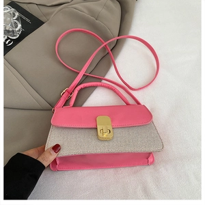 Detailed view of pink and beige patchwork crossbody bag with gold metal rotating lock