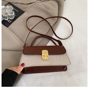 Detail view of a vintage crossbody bag with gold square metal lock and canvas stitching