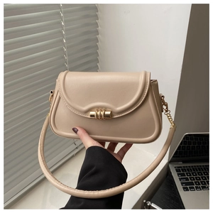 Detailed close-up of beige crossbody bag featuring a golden metal twist lock and leather strap