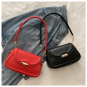Detail of red and black baguette bags with gold cylindrical metal locks and chain straps