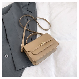 Detail view of khaki leather crossbody bag with elegant gold metal twist lock
