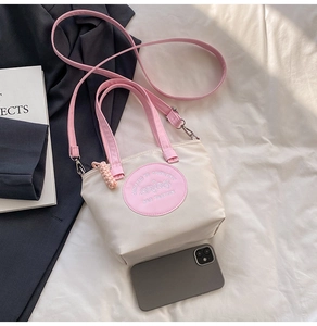 Détail d'un sac cabas en nylon bicolore avec anses roses et bandoulière réglable
