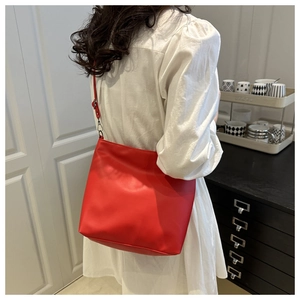 Détail d'un sac seau minimaliste en cuir rouge avec des ferrures en métal argenté