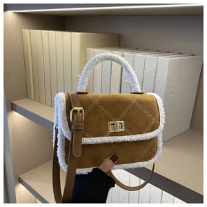 Detail of brown quilted bag with white shearling trim and golden metal square lock