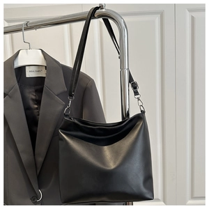 Détail de la bandoulière réglable et boucle argentée sur sac fourre-tout noir épuré