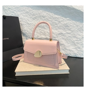 Détail du sac rose embossé croco avec boucle géométrique dorée irrégulière