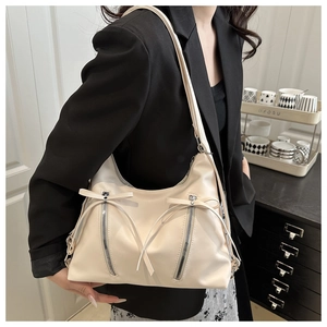 Détail du sac bandoulière blanc crème en cuir avec nœuds et fermetures éclair verticales