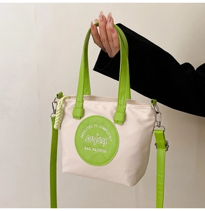 Détail du sac en nylon contrasté avec bandoulières vert fluo et patch rond chic
