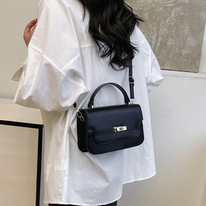 Chic black matte leather crossbody bag with gold buckle shown on a model's back