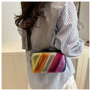 Macro detail of the colorful diagonal stripes and metallic texture on this trendy crossbody bag