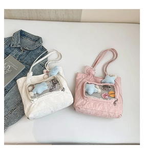 Detail of pleated nylon tote bag with transparent PVC window and plush star charms